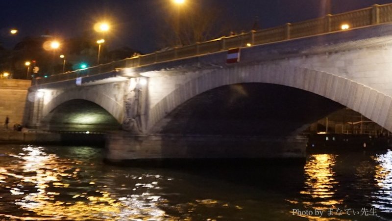 夜の川にかかるアーチ状の石造りの橋